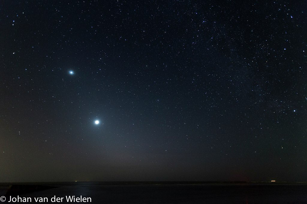 Houten golfbreker in de nacht, aan de hemel de planeten Venus en Jupiter.