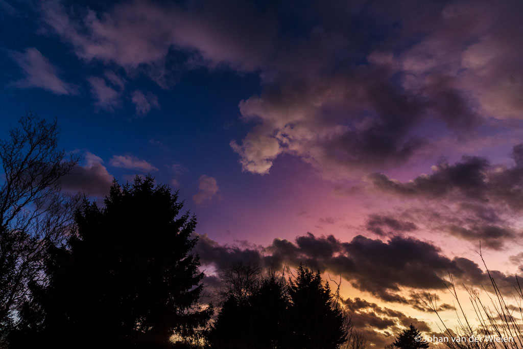 Zeldzame parelmoerwolken, diepe paarskleuring door aanbelichting na zonsondergang. 