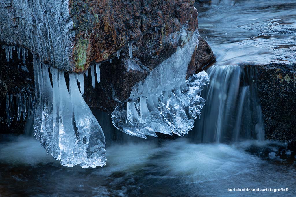 Mooie details bij het water zoals ijsklompen aan een steen, vanaf statief.